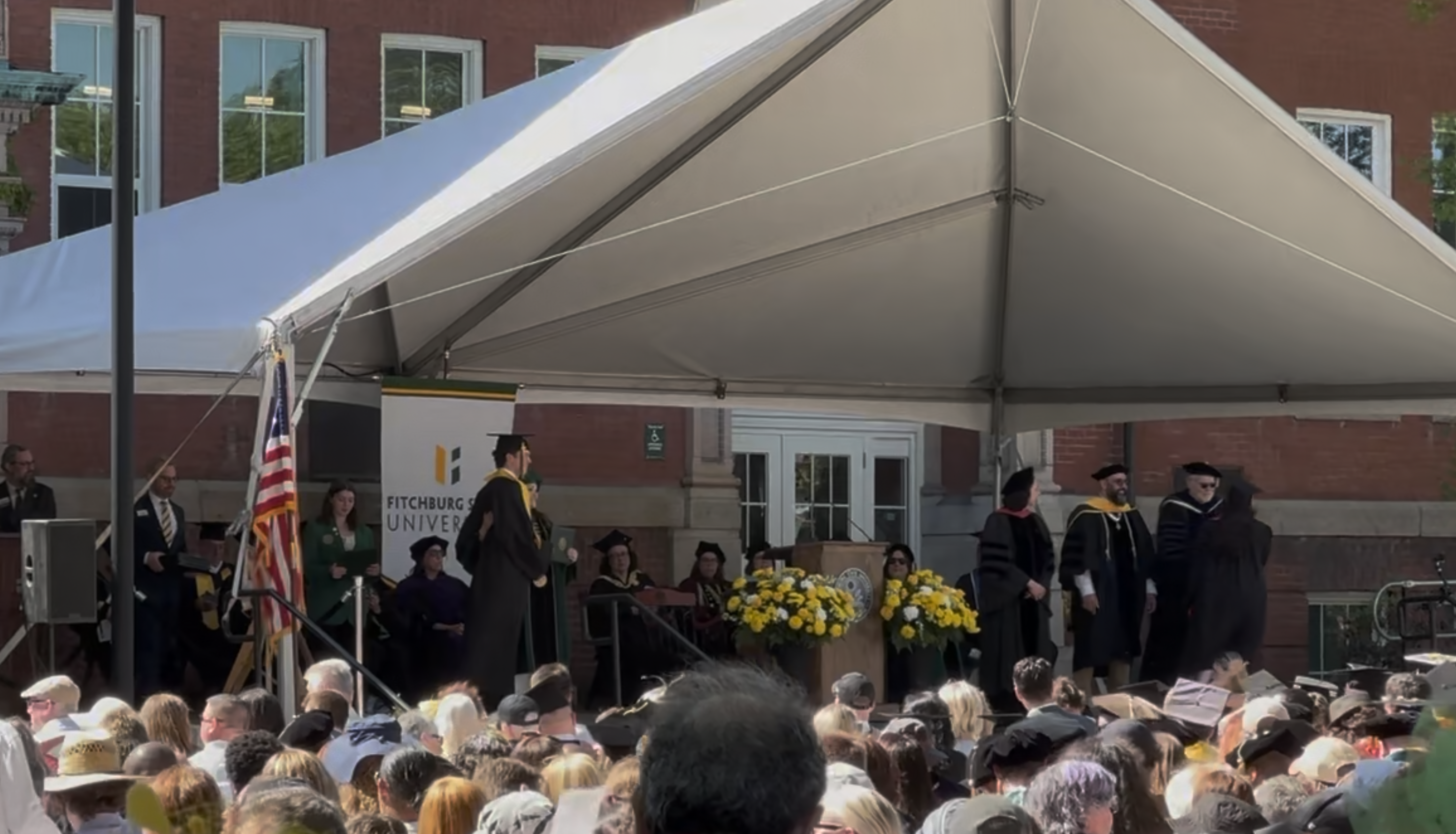 Fitchburg State University commencement — graduates on stage receiving diplomas