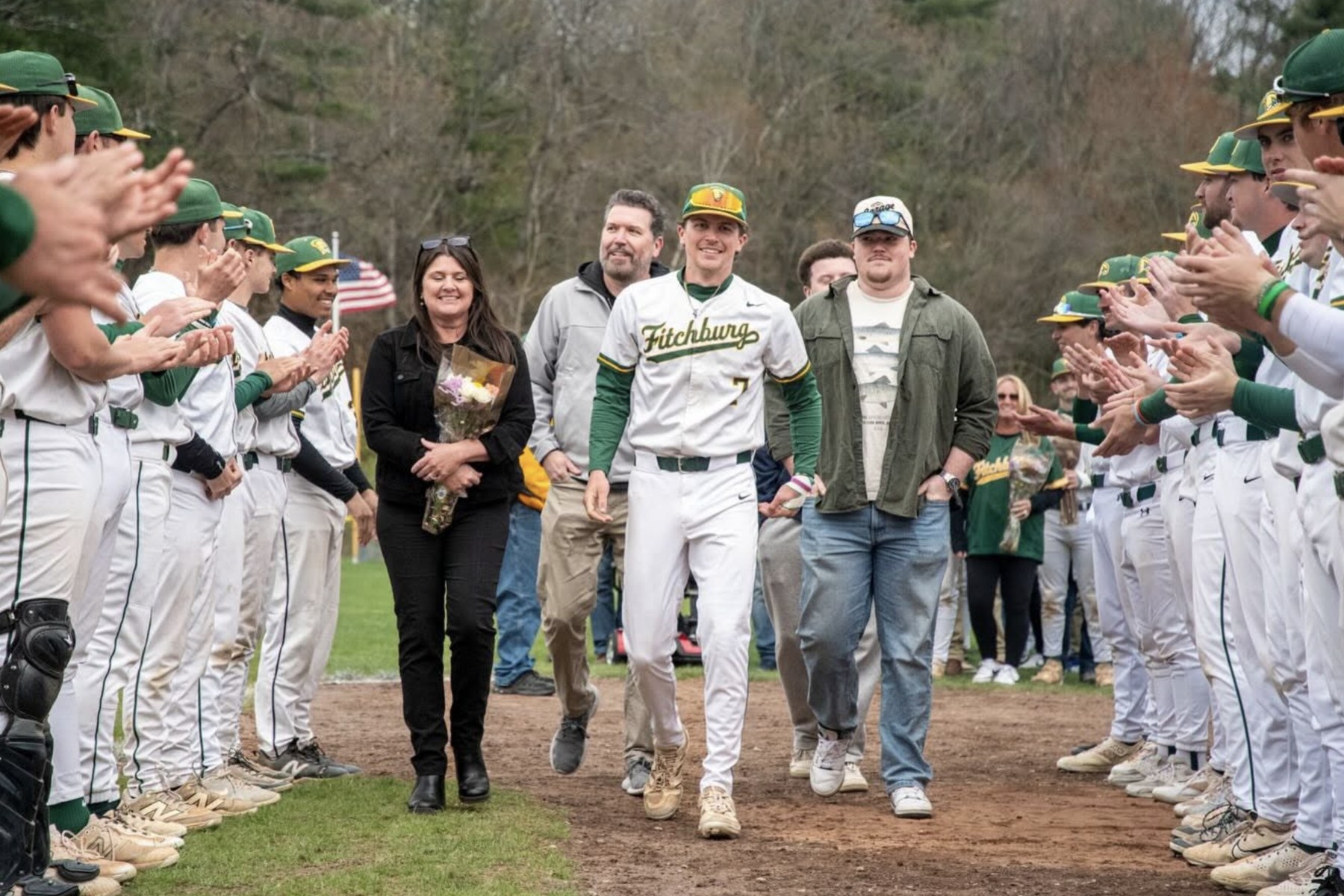 Casey Bellew on senior day at Fitchburg State, walking through the team tunnel with family